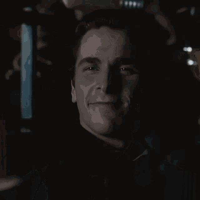 a close up of a man 's face with a slight smile on his face