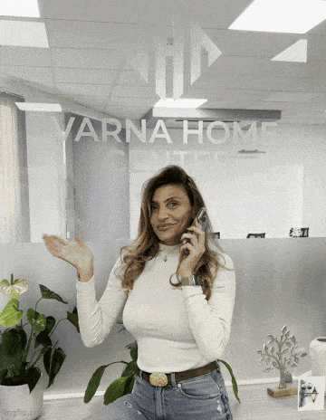 a woman talking on a cell phone in front of a varna home center window