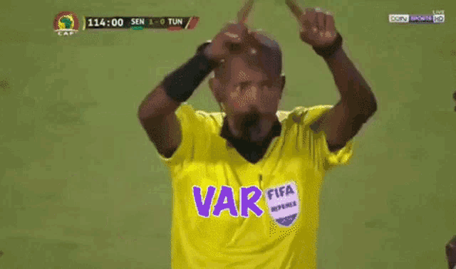 a soccer referee has the word var written on the screen