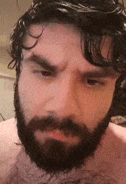 a man with a beard and curly hair is making a funny face