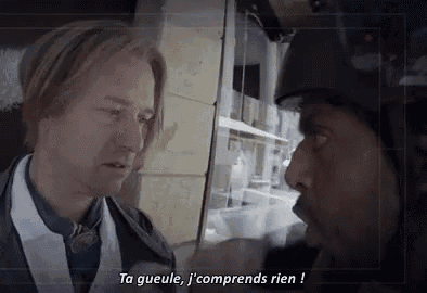 a man in a helmet is talking to another man in a white shirt .