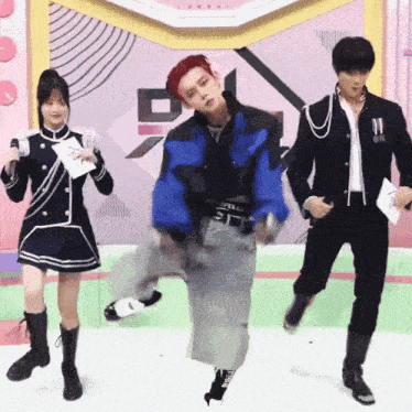 a man in a blue jacket is dancing with two other men