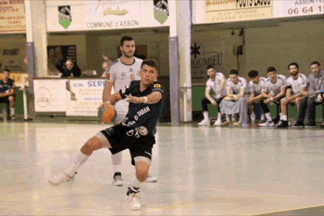 a man in a black shirt with el bahar on it dribbles a soccer ball