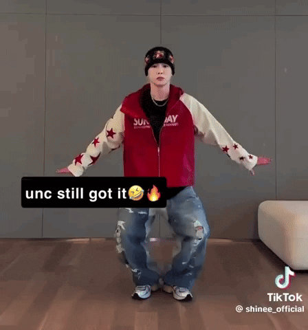 a man wearing a red jacket and a beanie is dancing on a tiktok video .