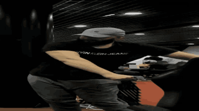 a man wearing a black calvin klein jeans shirt is dancing