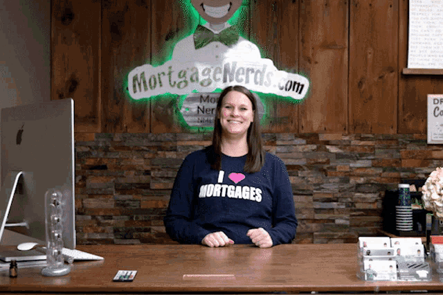 a woman wearing a sweater that says i love mortgages