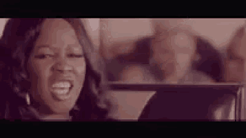 a woman is making a funny face in front of a mirror in a room .