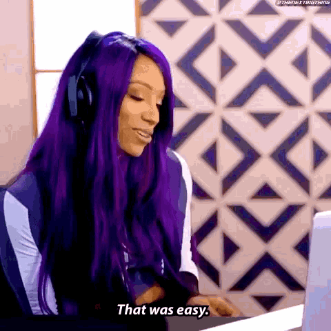a woman with purple hair is sitting in front of a laptop computer and says that was easy