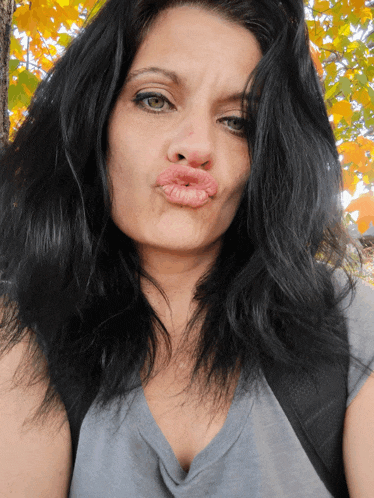 a woman with black hair is making a funny face with her lips