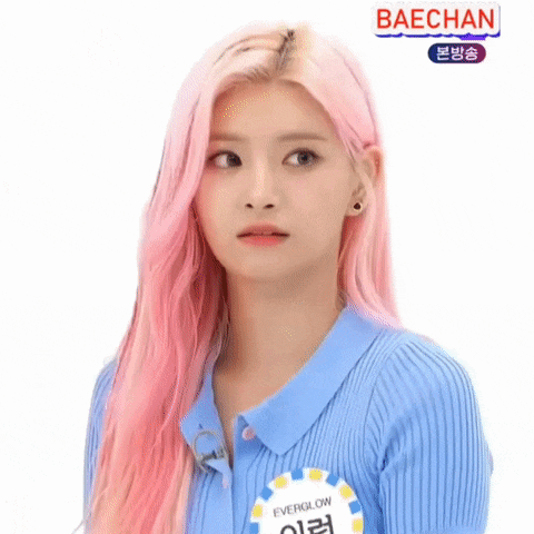 a girl with pink hair is wearing a blue shirt and a name tag .