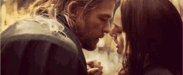 a man kissing a woman on the forehead in a close up