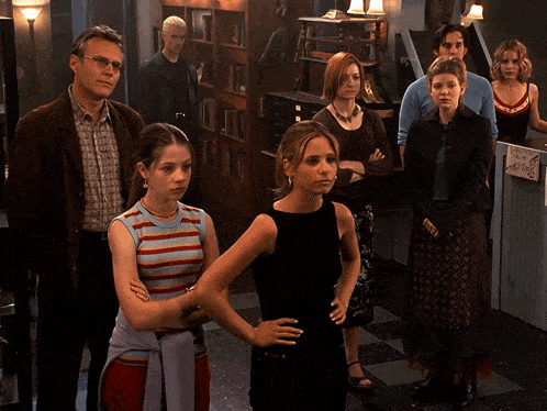 a group of people standing in a room with the words " we 're family " in the corner