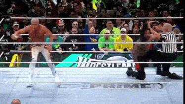a wrestling match is taking place in front of a crowd and the word prime is on the floor