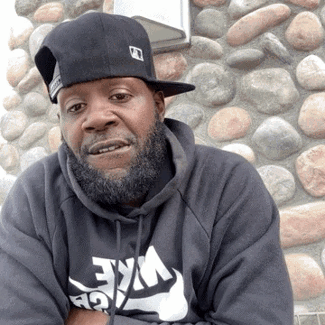 a man with a beard wears a nike hoodie