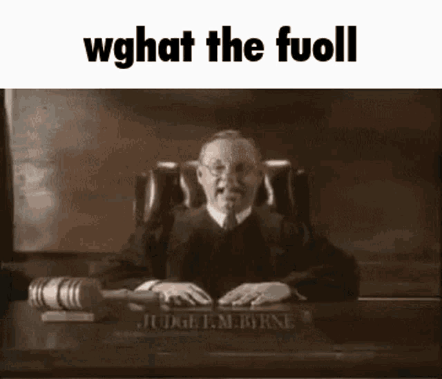 a judge is sitting at a desk in a courtroom holding a gavel and giving a speech .