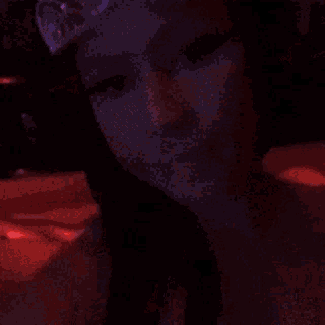 a close up of a woman 's face with a red light behind her
