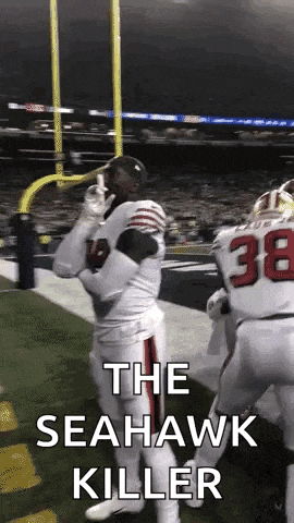 a football player is standing on the field with the words `` the seahawk killer '' written on the bottom .