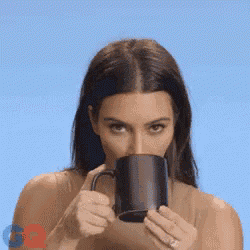 a woman is drinking from a black coffee mug
