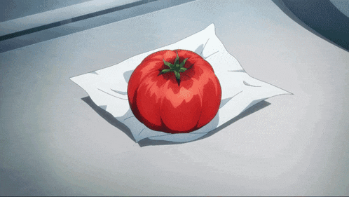 a tomato is sitting on a piece of white paper