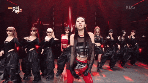 a group of women are dancing on a stage with a sign that says kbs on it