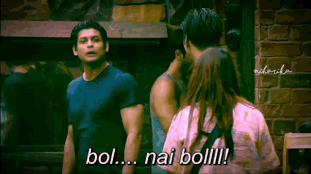 a man in a blue shirt stands next to a woman in a pink shirt and says bol nai bol