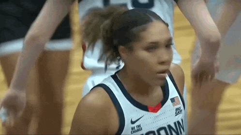 a female basketball player is wearing a jersey that says conn on it