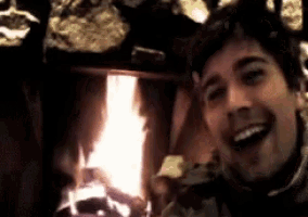 a man is taking a selfie in front of a fire