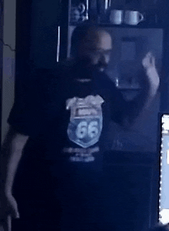 a man with a beard is wearing a black shirt with a route 66 logo on it .