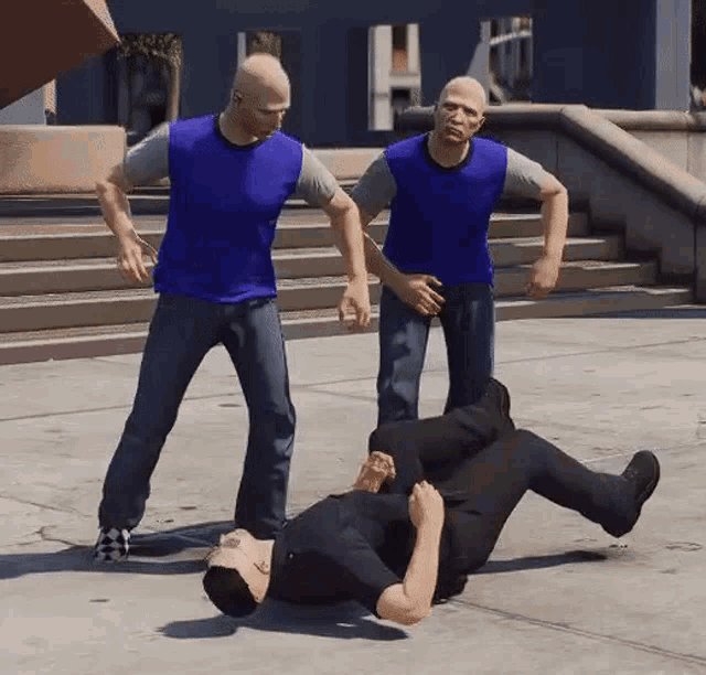 a man is laying on the ground with two men standing around him