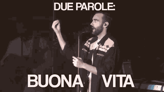 a man singing in front of a microphone with the words due parole buona vita below him