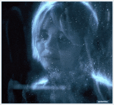 a close up of a woman 's face behind a glass with spideriliez written on the bottom right