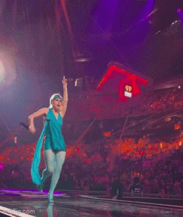 a woman in a blue dress is singing into a microphone