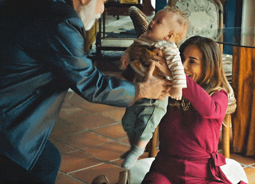 a man and a woman are holding a baby