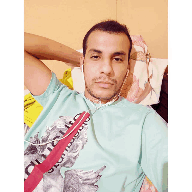 a man wearing ear buds and a shirt that says ' supreme ' on the front