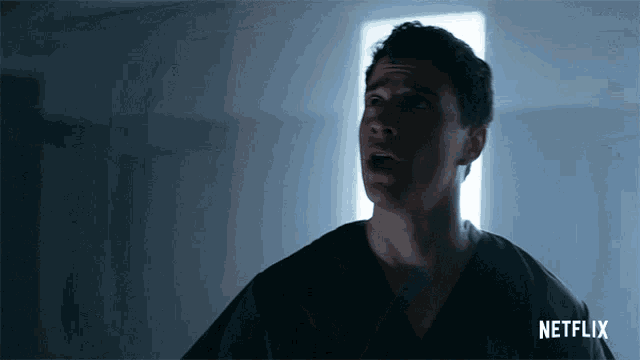 a man in a dark room with a netflix logo on the bottom right
