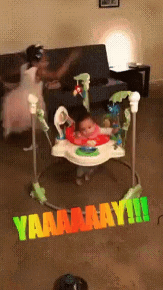 a baby sits in a bouncer with a sign that says yaaaamay