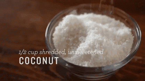 a glass bowl filled with shredded coconut on a table