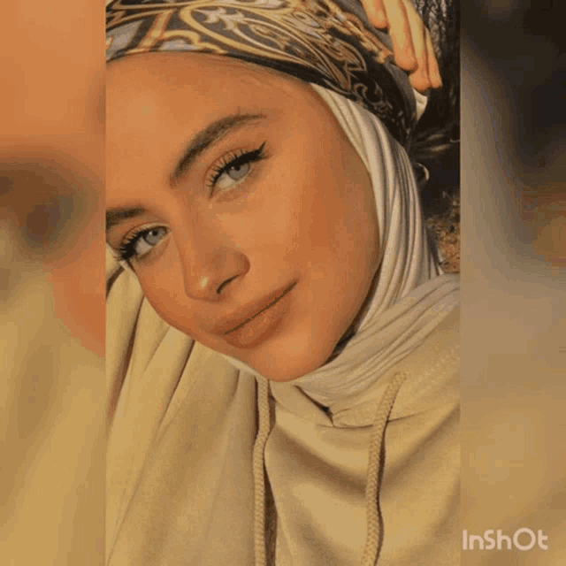 a woman wearing a blue scarf and a black shirt has the word inshot on the bottom