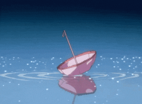 a pink umbrella is floating on the water