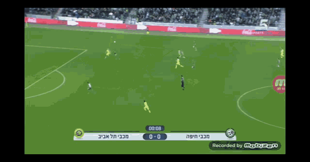 a soccer game is being recorded with a coca cola ad in the background