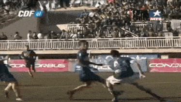 a soccer game is being played in front of a crowd with a banner that says cdf on it
