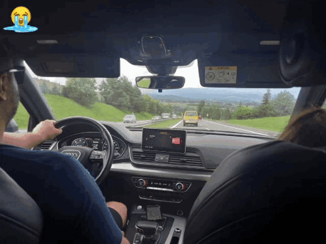 a man driving a car with a sticker on the windshield that says ' airbag '