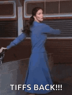 a woman in a red dress is dancing with the words tiffs back written on the bottom