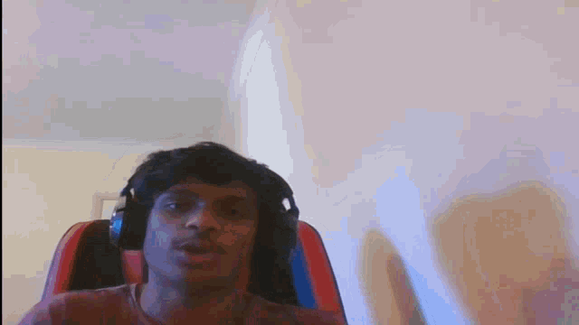 a man wearing headphones sits in a red chair