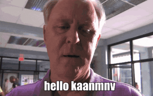 an older man says hello kaanmnv in a purple shirt