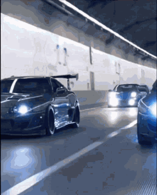 cars are driving down a tunnel with the number 11 on the wall behind them