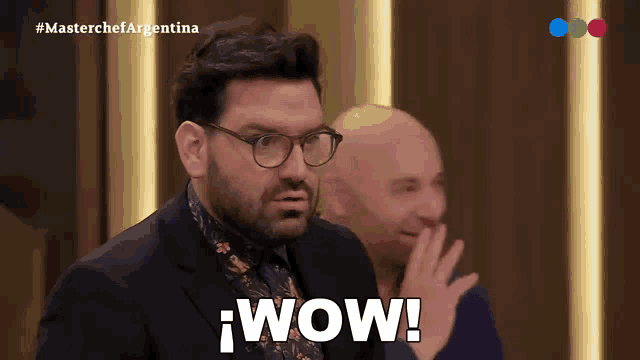 a man in a suit and glasses says wow in spanish
