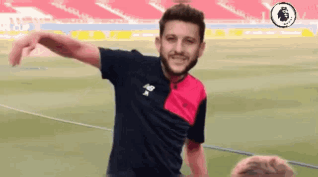 a man with a beard is standing on a soccer field .