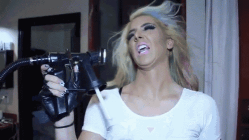 a woman in a white shirt is spraying her face with a spray gun