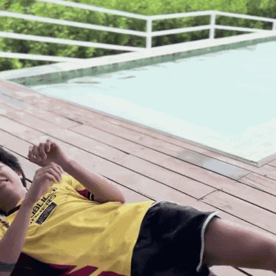 a person laying on a wooden deck with a yellow shirt that says ' apollo ' on it